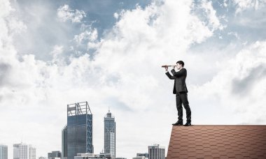 evin çatısında duran işadamı