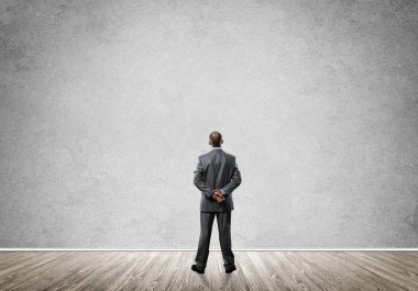 Boş beton duvara bakarak işadamı