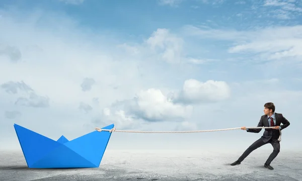 Бизнесмен тянет веревочную бумажную лодку — стоковое фото