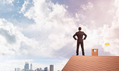 evin çatısında duran işadamı