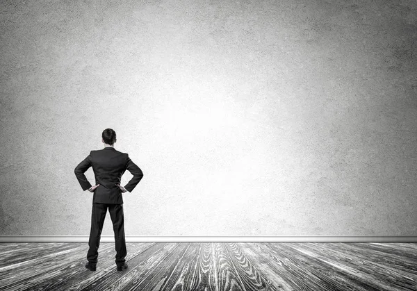 Boş beton duvara bakarak işadamı