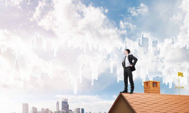 evin çatısında duran işadamı