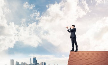 evin çatısında duran işadamı