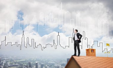 evin çatısında duran işadamı