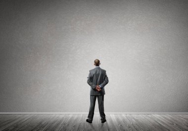 Boş beton duvara bakarak işadamı