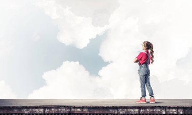 Sevimli kız çatı yapı üzerinde ayakta