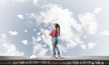 Sevimli kız çatı yapı üzerinde ayakta