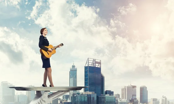 Приваблива бізнес-леді грає на акустичній гітарі — стокове фото