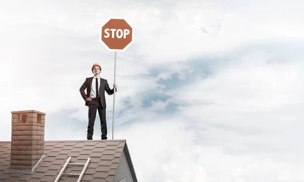 Geschäftsmann auf Dach zeigt Verkehrsschild — Stockfoto