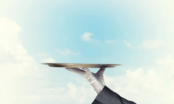 Waiter holding empty silver platter — Stock Photo, Image