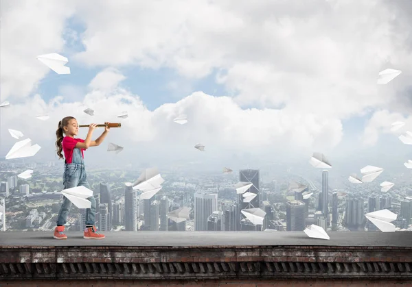 Schattige jongen meisje staande op het dak van het huis — Stockfoto