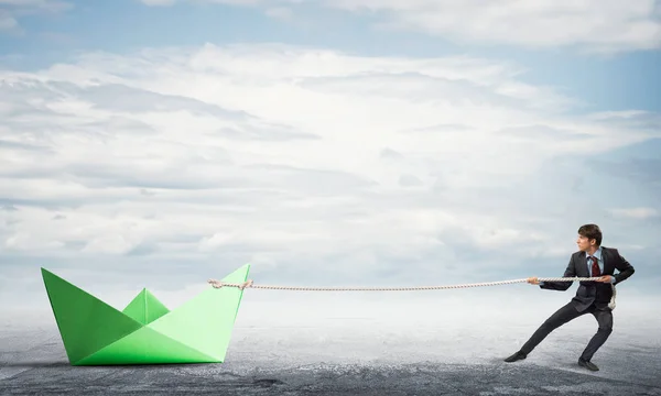 Empresario tirando con cuerda barco de papel — Foto de Stock