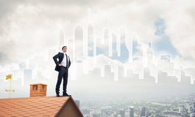 evin çatısında duran kararlı iş adamı  