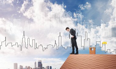 evin çatı kenarında duran işadamı 