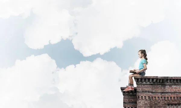 Linda niña sentada en el techo del edificio —  Fotos de Stock