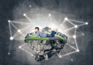 Okul çağındaki çim üzerinde yalan ve bu büyük gülümseyen sevimli çocuk 