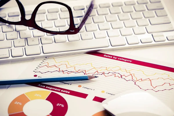 Keyboard and glasses with financial documents on table — Stock Photo, Image