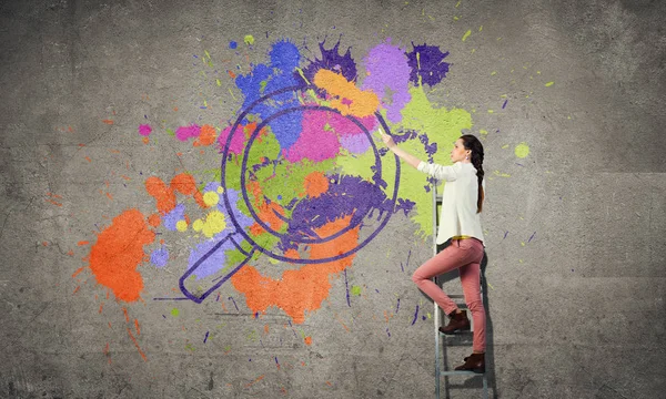 Genç kadın boyama duvar — Stok fotoğraf