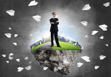 Yeşil yüzen ada üzerinde duran işadamı