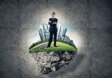 Yeşil yüzen ada üzerinde duran işadamı