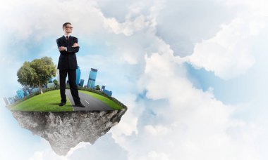 Yeşil yüzen ada üzerinde duran işadamı