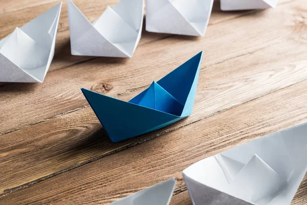 White and color paper boats on wooden table — Stock Photo, Image