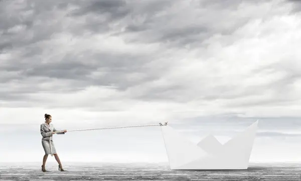 Femme d'affaires tirant avec une corde bateau en papier — Photo