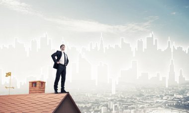 Evin çatısında duran genç işadamı 