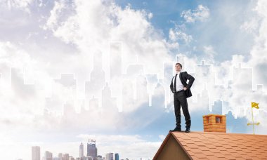 Evin çatısında duran genç işadamı 