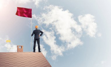 evin çatısında duran işadamı 