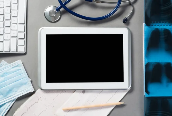 Tablet and medical items on gray surface — Stock Photo, Image