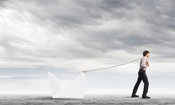 Empresario tirando con cuerda barco de papel — Foto de Stock