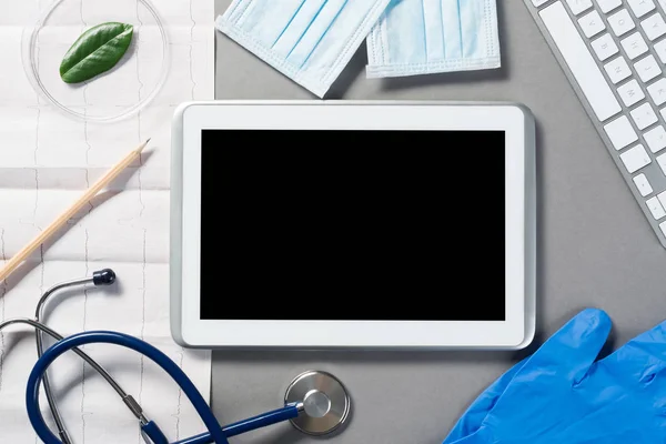 Tablet and medical items on gray surface — Stock Photo, Image