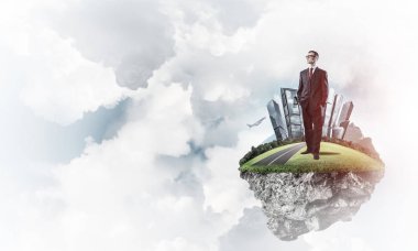 Yeşil yüzen ada üzerinde duran işadamı