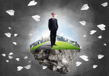 Yeşil yüzen ada üzerinde duran işadamı