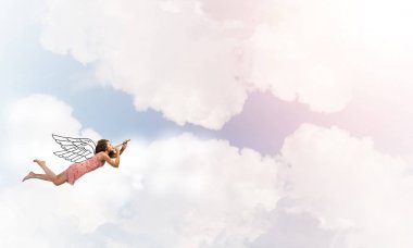 gökyüzünde uçan ve fife oynayan kadın