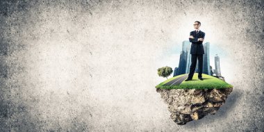 Yeşil yüzen ada üzerinde duran işadamı