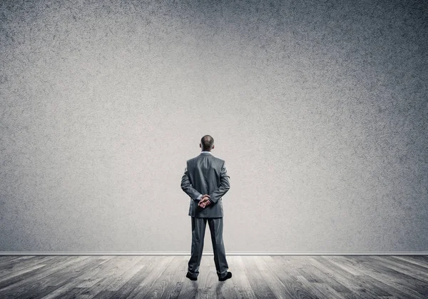 Businessman in empty concrete room — Stock Photo, Image