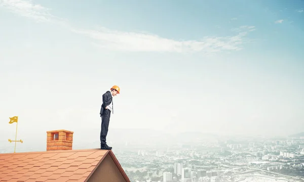 Hombre de negocios de pie en el borde del techo de la casa — Foto de Stock