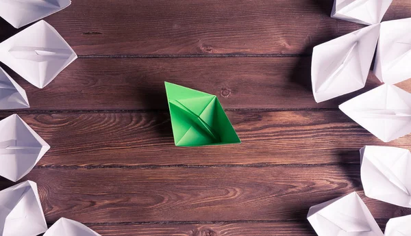 white and color paper boats on wooden table