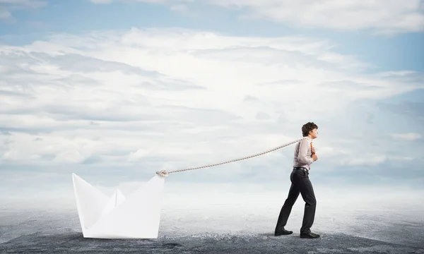 Businessman pulling with rope paper boat — Stock Photo, Image