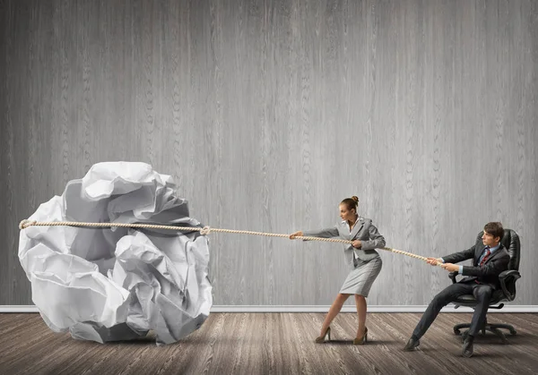 Businesspeople pulling crumpled ball — Stock Photo, Image