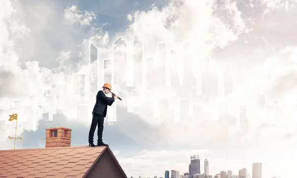Ο άνθρωπος στέκεται στη στέγη και να αναζητούν σε spyglass. — Φωτογραφία Αρχείου