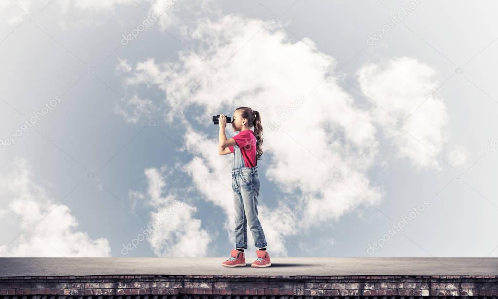 girl looking in binoculars on building roof