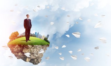 Yeşil yüzen ada üzerinde duran işadamı