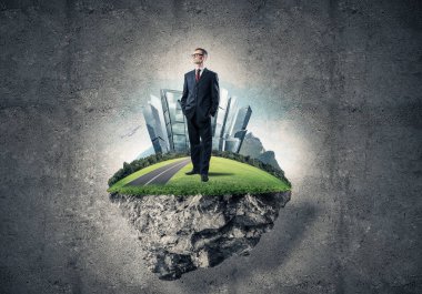 Yeşil yüzen ada üzerinde duran işadamı