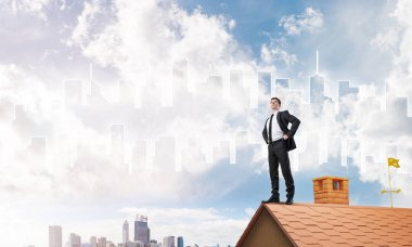 Evin çatısında duran genç işadamı 