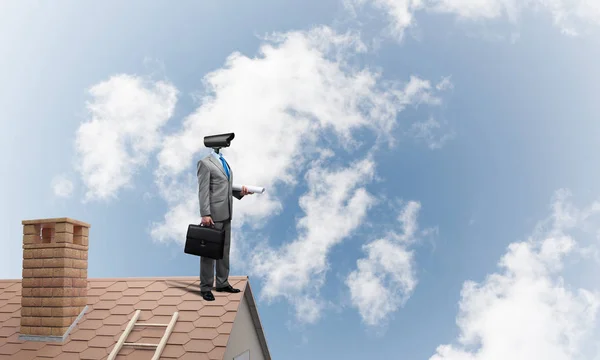 Hombre de negocios con zoom de cámara en el techo de la casa —  Fotos de Stock