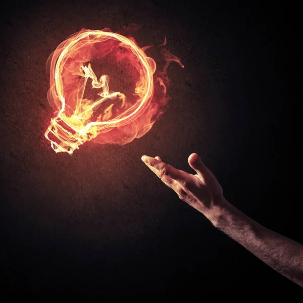 Hand showing at glowing light bulb — Stock Photo, Image