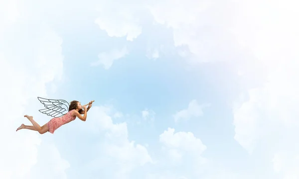 Женщина, летящая в небе и играющая в фифе — стоковое фото